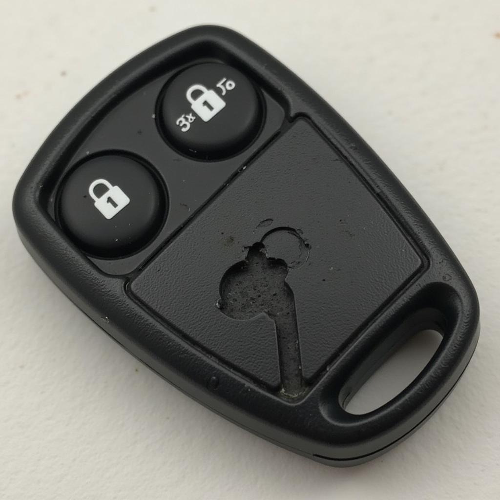 2015 Honda Accord Key Fob Malfunctioning - A close-up view of a 2015 Honda Accord key fob with a cracked casing and worn buttons, indicating potential malfunction.